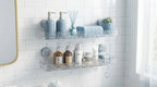 Transparent acrylic bathroom shelves mounted on a white tiled wall with blue-toned accessories in a modern, organized bathroo